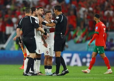 Portugal's Otavio, Bruno Fernandes and Ruben Neves argue with referee Facundo Tello. Reuters