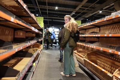 A woman in Kyiv looks at empty supermarket shelves after the curfew was lifted on February 28. Reuters