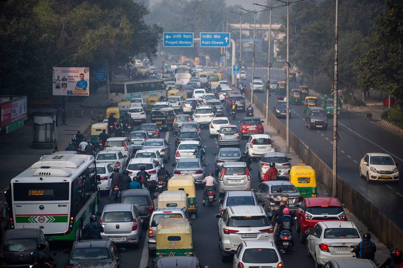 In this picture taken on November 25, 2021, people commute along a street amid smoggy conditions in New Delhi. AFP