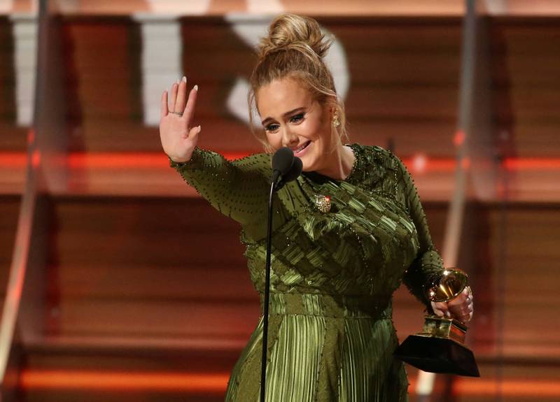 Adele waves to singer Beyonce who is in the audience as she and co-song writer Greg Kurstin accept the Grammy for Song of the Year for "Hello" at the 59th Annual Grammy Awards in Los Angeles, California, US, on February 12, 2017.  Reuters