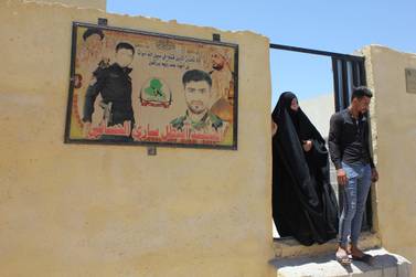 Sahla AlHasani and her son outside their house funded by Asaib Ahl Al Haq. Lizzie Porter/ The National