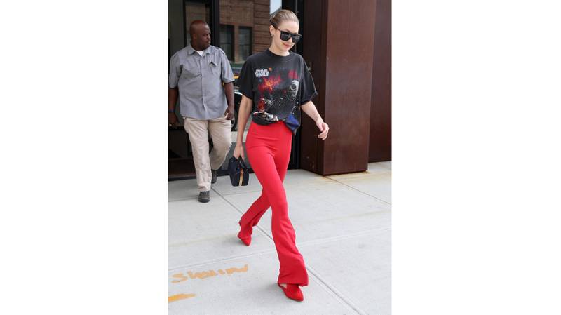 Gigi Hadid gave a casual touch to the dramatic red trousers by pairing them with a baggy Star Wars T-shirt. Courtesy Backgrid