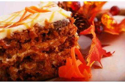 carrot cake on a plate garnished with autumn leaves