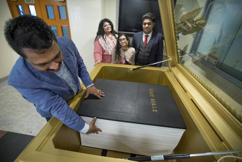 Dubai, United Arab Emirates - Manoj Varghese measuring the thickness of the world's biggest handwritten bible which is at 46.3cm at Dubai Mar Thoma Church, Jebel Ali.  Leslie Pableo for The National for Gillian Duncan's story