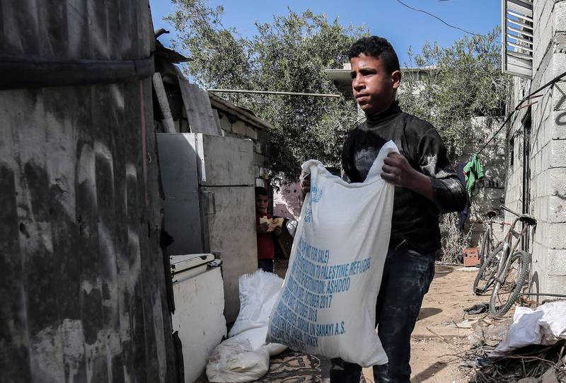 A Palestinian man delivers food aid provided by the UN agency for Palestinian refugees to a family in the Rafah refugee camp in the southern Gaza Strip on January 24, 2018.
The head of the United Nations agency for Palestinians said last week the US decision to freeze tens of millions of dollars in aid resulted from diplomatic disputes rather than the agency's performance. / AFP PHOTO / SAID KHATIB
