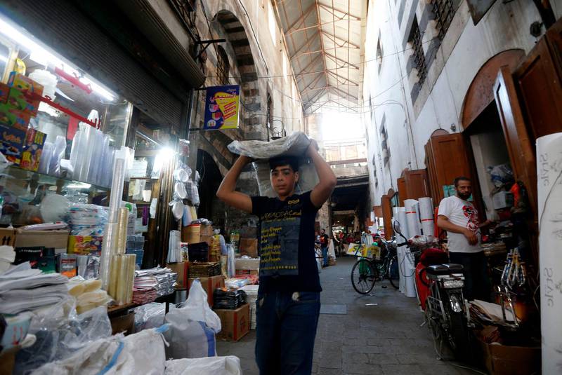 A Syrian boy carrying textiles is pictured in the bazaar in old Damascus. AFP