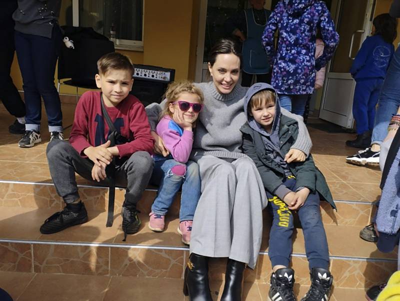 Angelina Jolie, Hollywood movie star and UNHCR goodwill ambassador, poses for photo with kids in Lviv, Ukraine. AP