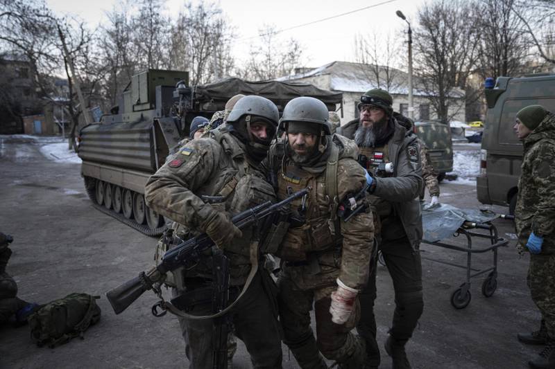 An injured Ukrainian troop is helped from the battlefield by comrades in Donetsk region and taken to hospital. AP