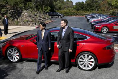 Mr Musk with then Japanese prime minister Shinzo Abe after a test drive of the Tesla Model S P85D in Palo Alto, California, in 2015 Reuters