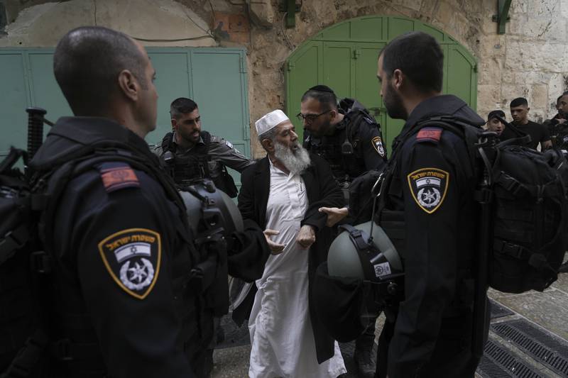 Israel police argues with a Palestinian worshipper in the Old City of Jerusalem, Sunday, April 17, 2022.  Israeli police cleared Palestinians outside Al-Aqsa Mosque to facilitate the routine visit of Jews to the holy site and accused Palestinians of stockpiling stones in anticipation of violence. AP