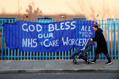  A woman passes with a stroller a banner showing support for the NHS, as the spread of the coronavirus disease (COVID-19) continues, Belfast, Northern Ireland, April 6, 2020. REUTERS/Jason Cairnduff