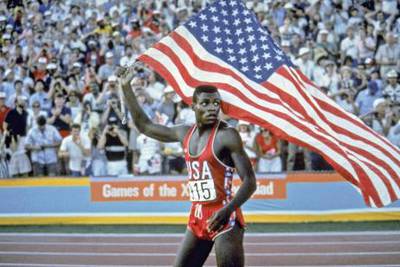 Carl Lewis takes a victory lap around the track of the Los Angeles Coliseum Saturday, August 4, 1984 after winning the gold medal in the 100-meter dash.(AP Photo, The Los Angeles Times/Skeeter Hagler)