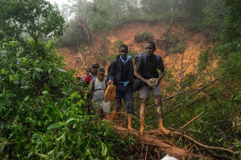 School students of St. Charles Luanga, rescued by members of the Zimbabwe Military, walk past a mudslide, covering a major road at Skyline junction in Chimanimani, Manicaland Province, Zimbabwe. AFP