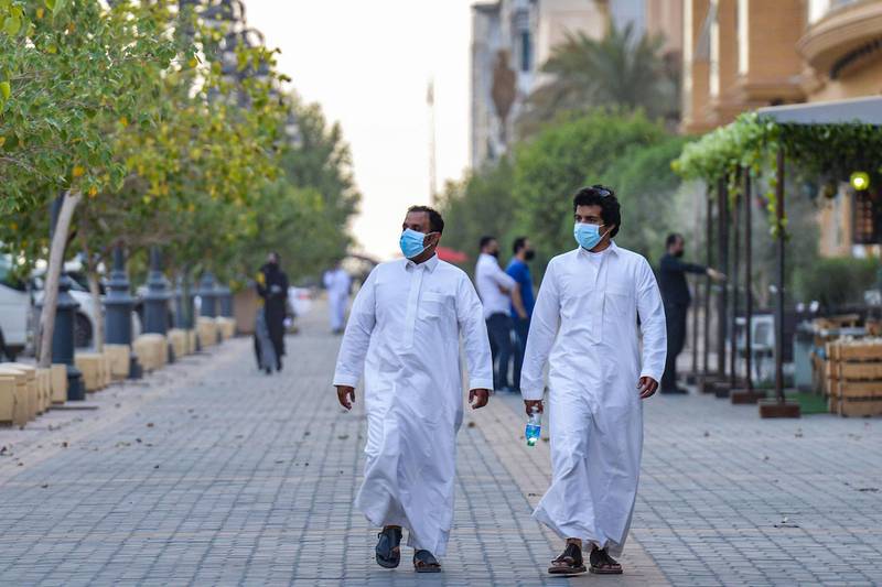 Mask-clad men walk along the promenade of Tahlia street in the centre of Saudi Arabia's capital Riyadh.   AFP