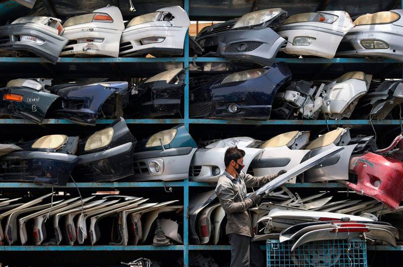 A worker arranges car parts at a spare parts shop in the industrial area of Dubai.  AFP