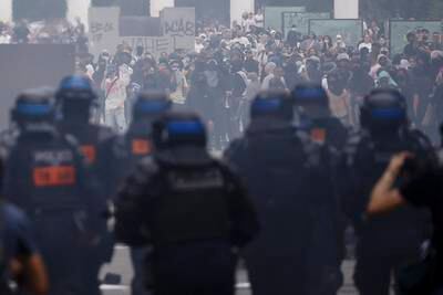 Protesters stand amid tear gas during clashes with French riot police over the death of a teenager known as Nahel M. EPA