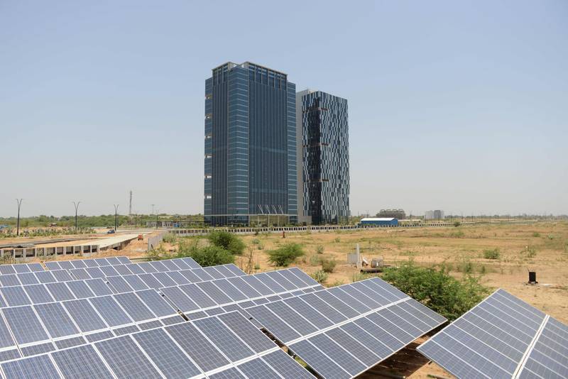 Buildings and solar panels, part of the Gujarat International Finance Tec-City (GIFT City), India's first "Smart City", are seen on the outskirts of Gandhinagar, some 30 km from Ahmedabad on May 18, 2015. GIFT City, the brain child of Indian Prime Minister Narendra Modi, is an under-construction central business district for the Indian state of Gujarat  AFP PHOTO / Sam PANTHAKY (Photo by SAM PANTHAKY / AFP)