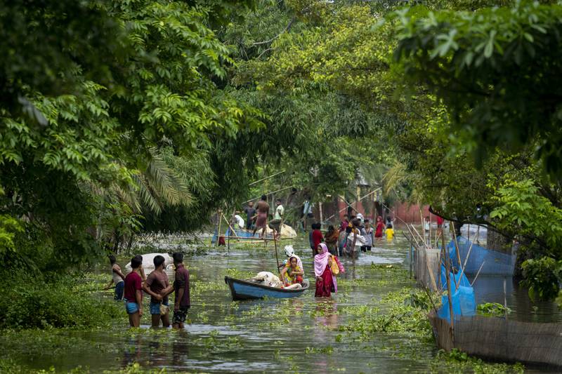 People leave the submerged village of Tarabari in the north-eastern Indian state of Assam and head for higher ground to escape rising floodwater. AP