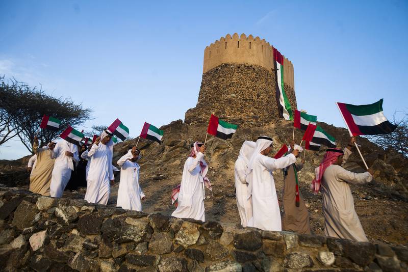 Journey of the Union participants raise the flag after stopping at the Emirate’s oldest fort and mosque at Fujairah. Lee Hoagland / The National