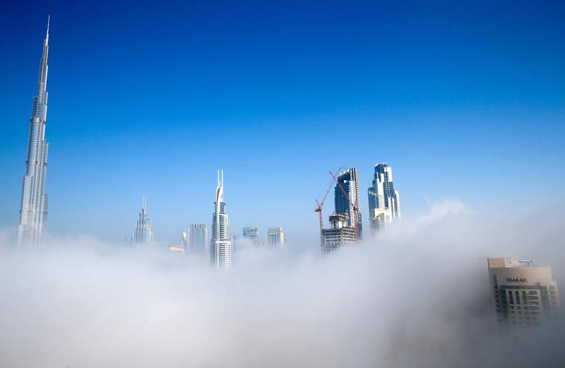 epa08974748 (FILE) - A view of the world's tallest building of Burj Khalifa (L) among other skyscrapers during foggy weather in the Gulf emirate of Dubai, United Arab Emirates, 19 January 2021 (reissued 30 January 2021). Dubai ruler and UAE Prime Minister Al Maktoum on 30 January 2021 announced that the United Arab Emirates (UAE) would open citizenship for selected foreigners, namely 'investors, specialised talents and professionals including scientists, doctors, engineers, artists, authors and their families'.  EPA/ALI HAIDER