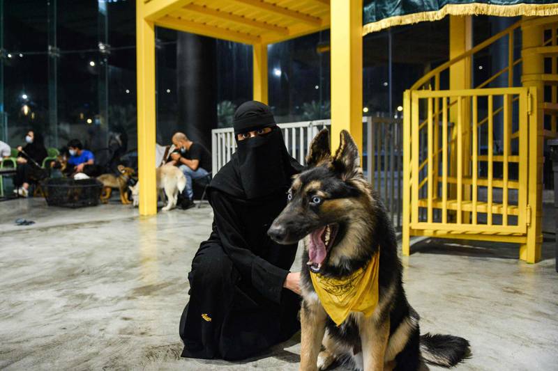 A woman sits with her German shepherd at the Barking Lot cafe in Khobar. AFP