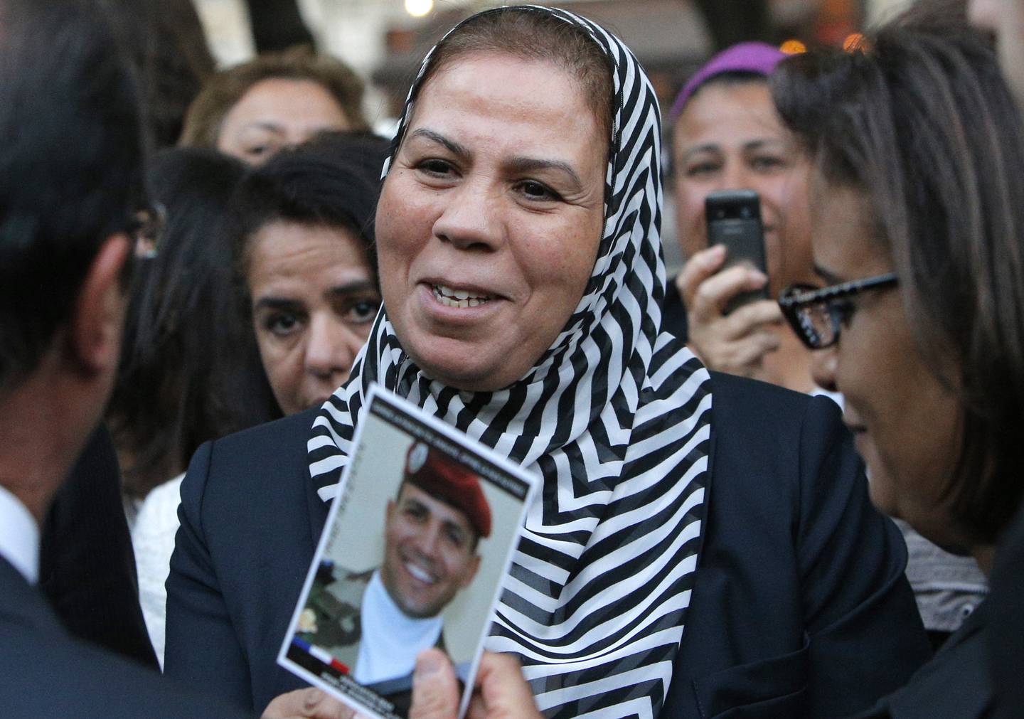 Latifa Ibn Ziaten shows a photo of her son killed by Mohamed Merah to then French president Francois Hollande 