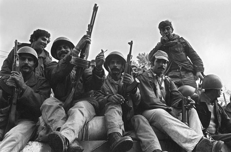 Syrian soldiers, members of the joint Arab "green helmets" peace-keeping force to Lebanon, atop a Russian-made tank, take position 15 November 1976 in Beirut. In early June 1976, Syria launched a full-scale invasion of Lebanon officially to end the civil war and restore peace, but unofficialy, it became clear, to crush the Palestinians. During the course of the fighting there had been more that 50 abortive cease-fires and an estimated 60,000 people had been killed and some 100,000 injured. The Lebanese civil war erupted in April 1975. AFP PHOTO XAVIER BARON (Photo by XAVIER BARON / AFP)