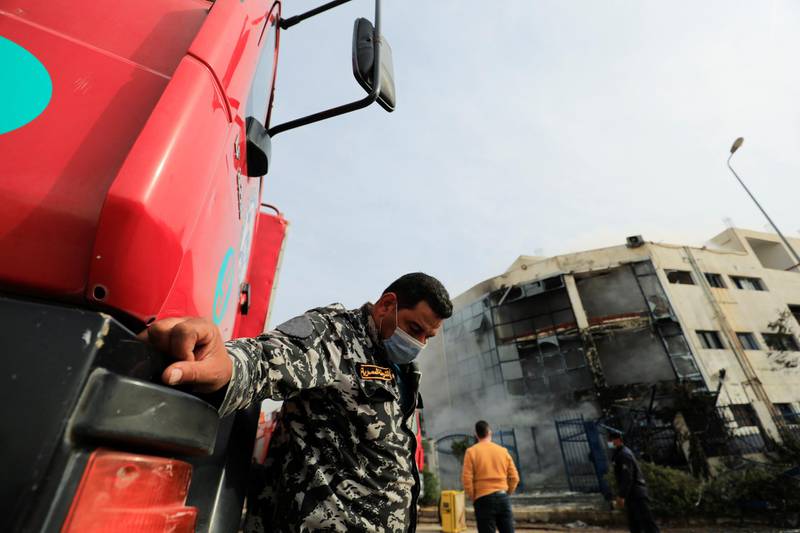 A policeman guards near firefighter truck at the scene after a fire broke out in a garment factory north of Cairo, Egypt March 11, 2021. REUTERS/Amr Abdallah Dalah