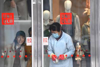 A worker wearing a protective mask is seen inside a shop at a mall in Beijing. AFP