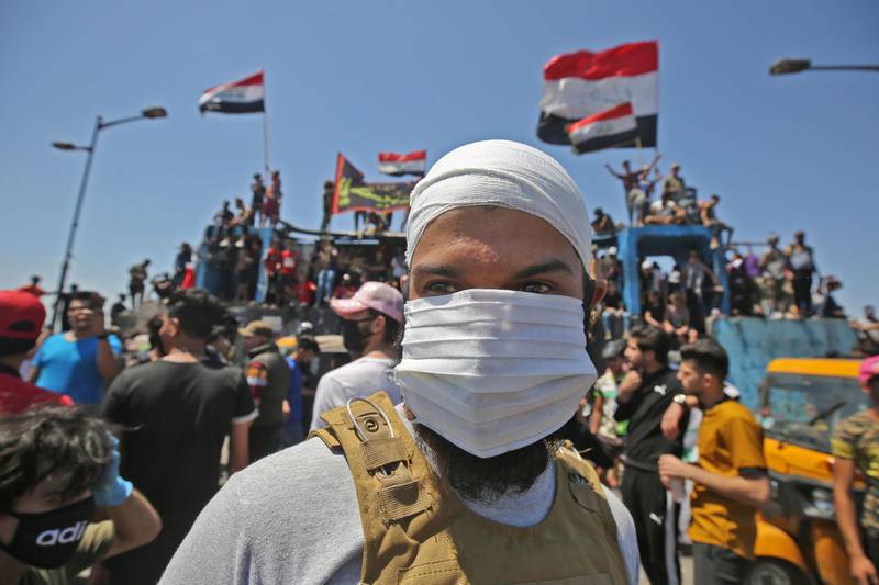TOPSHOT - An Iraqi protester wears a face mask during an anti-government demonstration on Al-Jumhuriyah bridge in the capital Baghdad, on May 10,2020.  Modest anti-government rallies resumed in some Iraqi cities today, clashing with security forces and ending months of relative calm just days after Prime Minister Mustafa Kadhemi's government came to power. / AFP / AHMAD AL-RUBAYE
