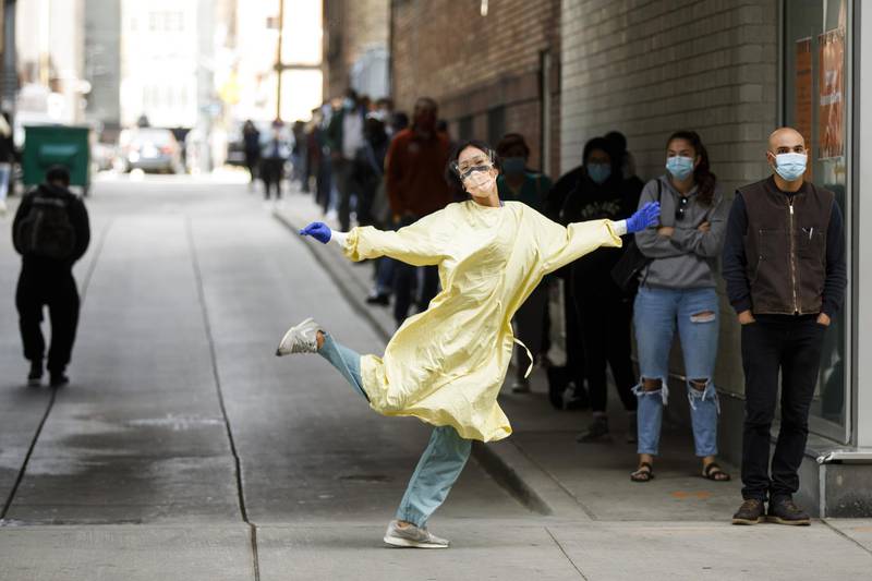 A healthcare worker poses for a photograph while walking towards a line of patients waiting outside a Covid-19 testing centre at St. Michael's Hospital in Toronto, Ontario, Canada on September 19. Cole Burston/Bloomberg