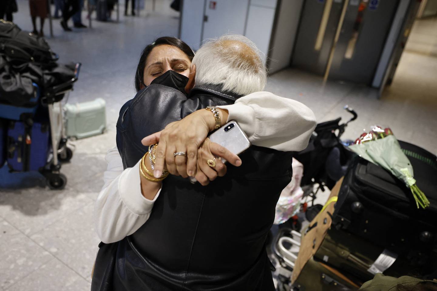 A man and woman embrace at the arrivals department of Heathrow Airport's Terminal 5. Photo: Tolga Akmen / AFP