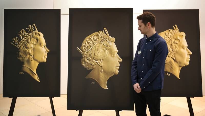 A Royal Mint engraver looks at the new coinage portrait, centre, of Queen Elizabeth at The National Portrait Gallery in London, 2015. Getty Images