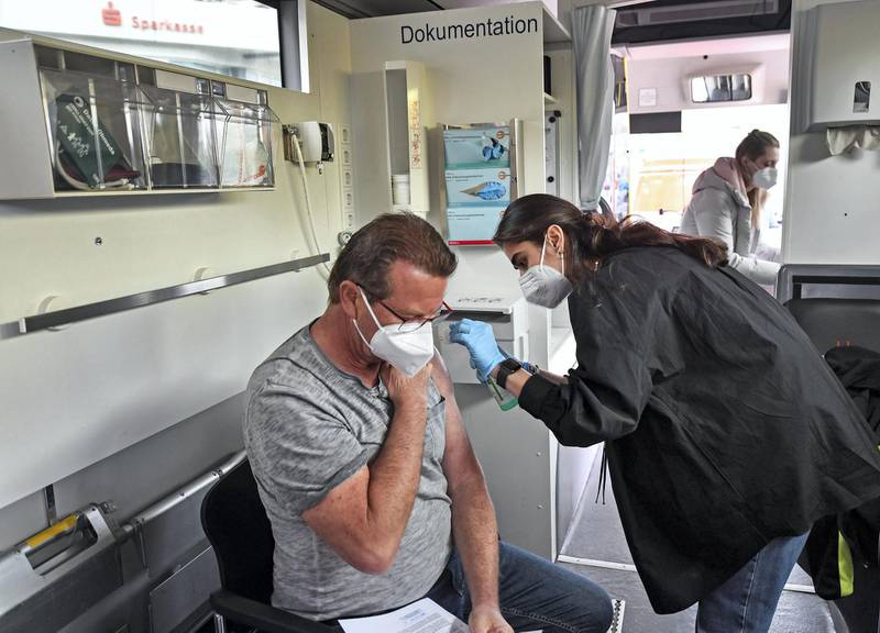 Harald Fischer gets a Moderna vaccination in a vaccination mobile on a square at the district  Chorweiler in Cologne, Germany, Monday, May 3, 2021. The city of Cologne started a program to bring COVID-19 vaccination to people living in this neighborhood with a high corona incidence. (AP Photo/Martin Meissner)