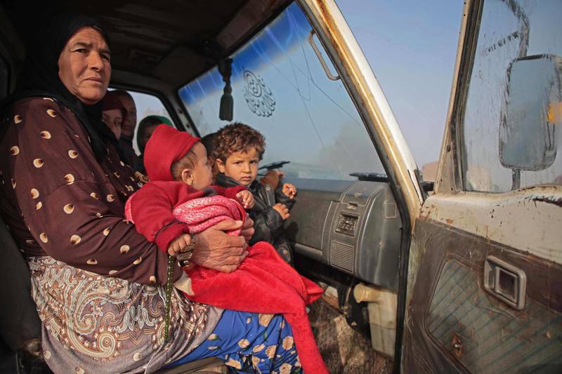 Syrians sit in a vehicle as they drive towards the northern areas of Syria's Idlib province near the Syrian-Turkish border as they flee the bombardments in the southern areas of the country's last major opposition bastion. AFP