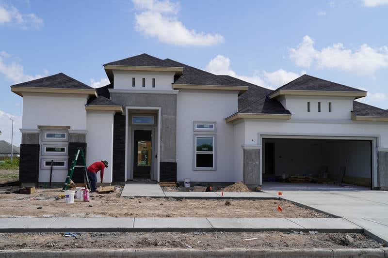 A construction worker builds a house in a new subdivision in Brownsville.