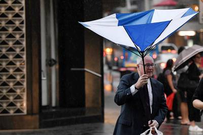 Pedestrians hold umbrellas as they walk in heavy rain in Sydney's central business district, New South Wales, Australia.  EPA