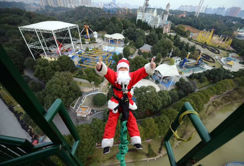 This picture, taken on December 18, 2014, shows a man dressed up as Santa Claus bungee-jumping at a theme park in Changsha, central China's Hunan province. The park organised a series of Santa Claus-themed events ahead of Christmas. AFP Photo

