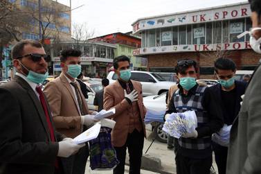 Activists in Kabul distribute fliers with information about the coronavirus on March 16, 2020 as the number of confirmed cases in Afghanistan reached 21. AP Photo