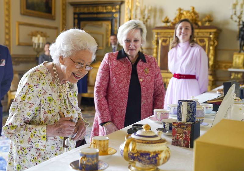 Queen Elizabeth II views a display of enamelware and china in the White Drawing Room at Windsor Castle on Thursday, to commemorate the 70th anniversary of British craftwork company, Halcyon Days. AP Photo