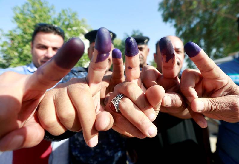 Iraqi security members show their ink-stained fingers after casting their vote at a polling station  in Najaf, Iraq. Alaa al-Marjani / Reuters