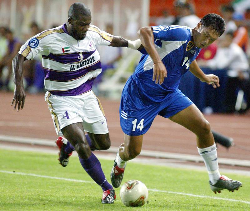 BEC Tero of Thailand player Worrawoot Srimaka (R) battles for the ball with Al Ain (United Arab Emirates) player Kadjo Julien Afanou (L) during the AFC Champions League final, second leg in Bangkok, 11 October 2003. BEC Tero draw with Al Ain 0-0 in half time. AFP PHOTO/Pornchai KITTIWONGSAKUL (Photo by PORNCHAI KITTIWONGSAKUL / AFP)