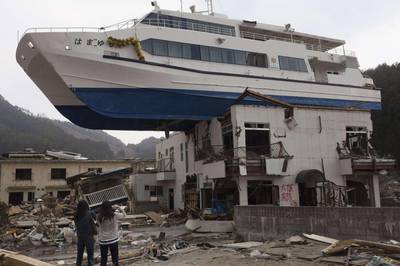 This combination of pictures shows a catamaran sightseeing boat washed by the tsunami onto a two-storey tourist home in Otsuchi, Iwate prefecture on April 16, 2011 (top) and the same area on January 16, 2012 (C) and then nearly two years later on February 18, 2013.  March 11, 2013 will mark the second anniversary of the massive tsunami that pummelled Japan, claiming some 19,000 lives.     AFP PHOTO / YASUYOSHI CHIBA (top)      AFP PHOTO / TORU YAMANAKA (C)    AFP PHOTO / TOSHIFUMI KITAMURA (bottom)