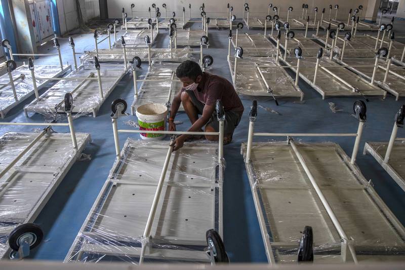 A workers installs beds at a makeshift Covid-19 care centre being set up in Mumbai, as infection rates surge in India. AP Photo
