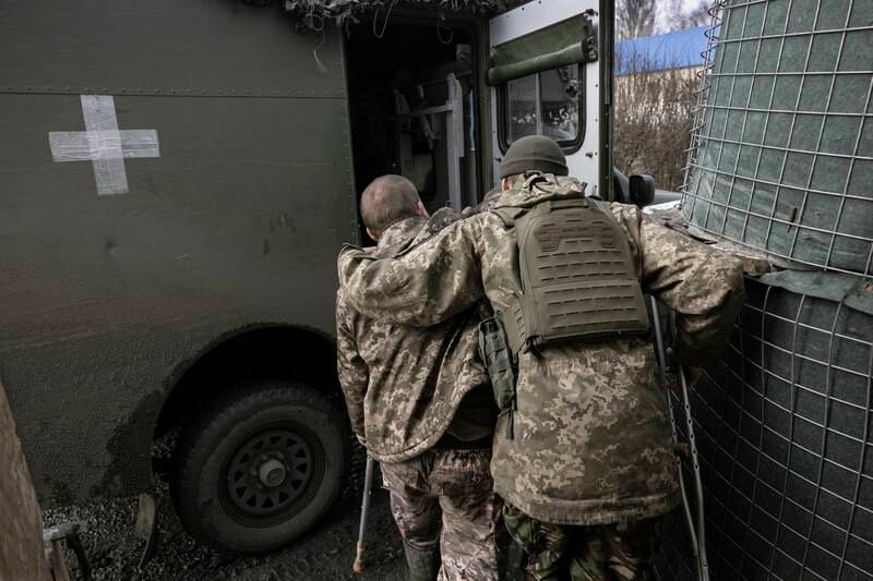 A medic helps an injured soldier into an evacuation ambulance in the Donbas region. Getty