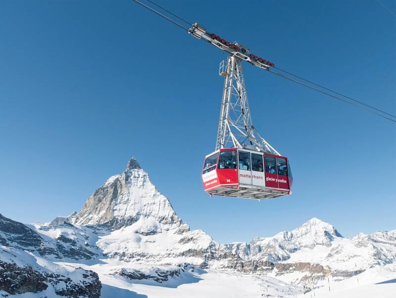 Zermatt, Switzerland - January 17, 2011: Skiers and snowboarders using the Matterhorn Glacier Paradise cable car, with the peak of the Matterhorn in the background.