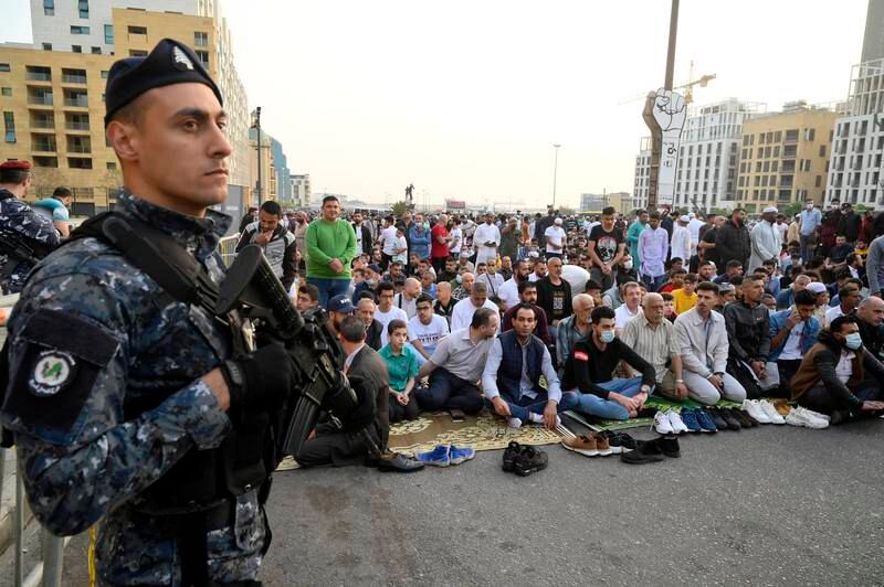 A soldier stands guard as people participate in the Eid al-Fitr prayers next to the 'Revolution Fist', outside Al-Amin Mosque in Martyr's Square, downtown Beirut, Lebanon. EPA