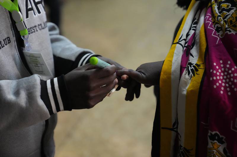 An election official marks the hand of a voter at the Kibera primary school in Nairobi. AP