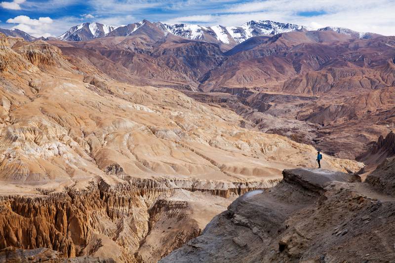 Nepal, Mustang. A trekker enjoying the extraordinary landscape on the approach to Dhi and Yara. Getty Images