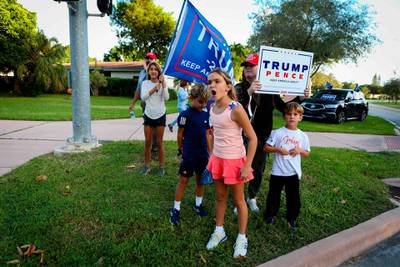 Supporters of US President Donald Trump rally in front of a poll station at Coral Gable Branch Public Library in Miami, Florida.  AFP